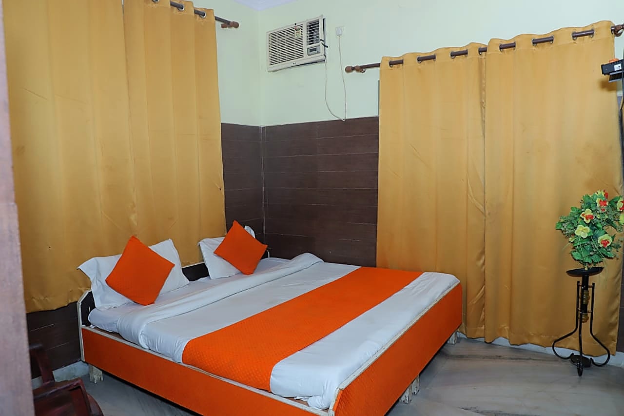 Double bed room with gold curtains, Hotel Chandreshwar