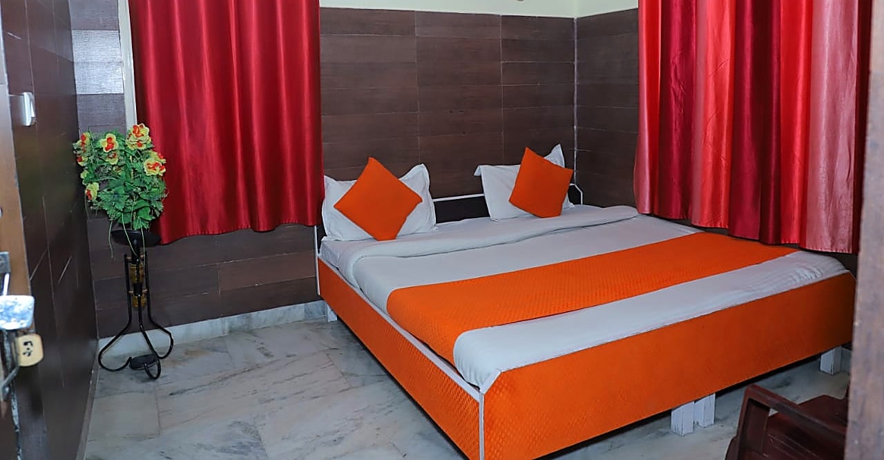 Double bed room with red curtains, Hotel Chandreshwar